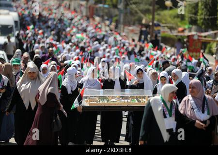 Le ragazze palestinesi hanno fatto ondeggiare le bandiere nazionali e il Santo Corano durante una marcia per avviare un campo estivo organizzato dal movimento di Hamas, a Gaza, il 04 giugno 2022. (Foto di Majdi Fathi/NurPhoto) Foto Stock