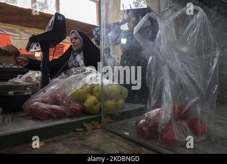 Una donna iraniana velata ricevette un disegno di legge da una cassiera mentre comperava in un negozio di frutta e verdura al Shapour Bazaar (mercato) nel sud di Teheran il 7 giugno 2022. (Foto di Morteza Nikoubazl/NurPhoto) Foto Stock