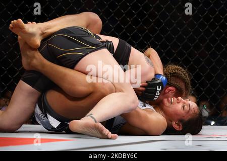 Valentina Shevchenko del Kirghizistan (TOP) batte Taila Santos del Brasile nel bout femminile del titolo di peso leggero durante l'evento UFC 275 al Singapore Indoor Stadium il 12 giugno 2022 a Singapore. (Foto di Suhaimi Abdullah/NurPhoto) Foto Stock