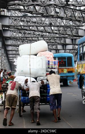 I lavoratori indiani spingono un furgone a caricare le merci attraverso il ponte Howrah a Kolkata, India, il 16,2022 giugno. (Foto di Debajyoti Chakraborty/NurPhoto) Foto Stock