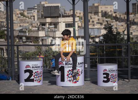 Nikan Zareian, un bungee boy iraniano di 11 anni, siede sul podio dei vincitori in attesa di esibirsi nella prima competizione acrobatica di bungee jumping iraniana nel Parco Adrenaline, nella parte nordoccidentale di Teheran, il 15 giugno 2022. La prima competizione acrobatica di bungee jumping in Iran si è tenuta all'Adrenaline Park, nella parte nordoccidentale di Teheran. (Foto di Morteza Nikoubazl/NurPhoto) Foto Stock