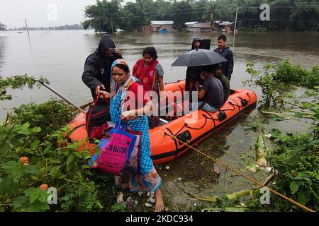 Le persone sbarcano una barca dopo essere state evacuate da un villaggio allagato nel distretto di Kamrup, nello stato nordorientale di Assam, India, 18,2022 giugno. (Foto di Anuwar Hazarika/NurPhoto) Foto Stock