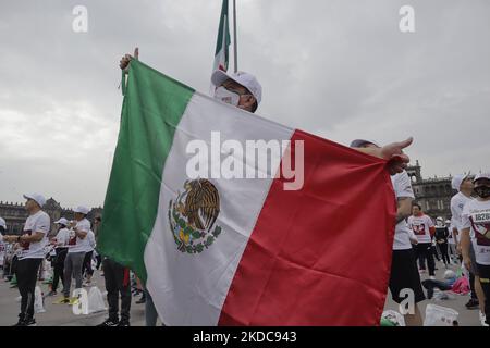 Una persona estende la bandiera messicana durante una massiccia classe di pugilato nella spianata di Zócalo di Città del Messico, che mira a stabilire un nuovo Guinness World Record superando quello stabilito nel 2017 in Russia, con 3.200 persone che prendono la classe allo stesso tempo per 30 minuti. (Foto di Gerardo Vieyra/NurPhoto) Foto Stock