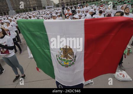 Una persona estende la bandiera messicana durante una massiccia classe di pugilato nella spianata di Zócalo di Città del Messico, che mira a stabilire un nuovo Guinness World Record superando quello stabilito nel 2017 in Russia, con 3.200 persone che prendono la classe allo stesso tempo per 30 minuti. (Foto di Gerardo Vieyra/NurPhoto) Foto Stock
