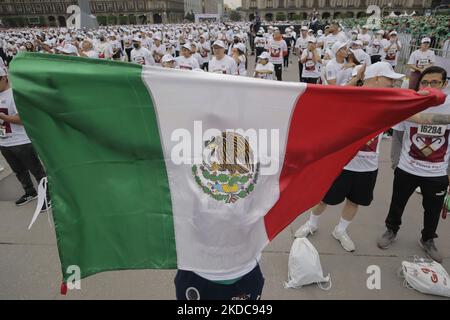 Una persona estende la bandiera messicana durante una massiccia classe di pugilato nella spianata di Zócalo di Città del Messico, che mira a stabilire un nuovo Guinness World Record superando quello stabilito nel 2017 in Russia, con 3.200 persone che prendono la classe allo stesso tempo per 30 minuti. (Foto di Gerardo Vieyra/NurPhoto) Foto Stock