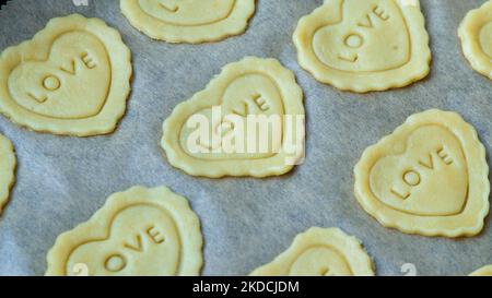 Biscotti fatti in casa con burro a forma di cuore con amore parola. Amore, romanticismo, San Valentino Foto Stock