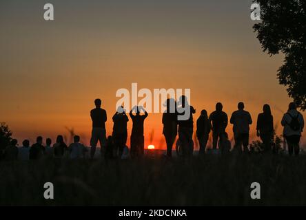 La gente guarda l'alba accanto al tumulo di Cracovia a Cracovia. Sabato 25 giugno 2022, nella piazza principale del mercato, Cracovia, Polonia. (Foto di Artur Widak/NurPhoto) Foto Stock