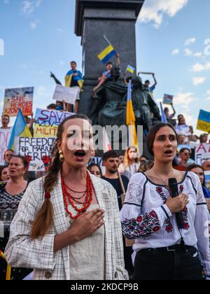 Gli ucraini cantano inno nazionale durante una manifestazione nella piazza principale a sostegno dei reggimento Azovstal 4308 difensori che attualmente sono in cattività russa. Cracovia, Polonia il 25th giugno 2022. Manifestazioni pacifiche sono state organizzate in tutto il mondo a sostegno di oltre 2.500 prigionieri di guerra Azovstal. Il Reggimento Azov era tra le unità ucraine che difesero l'acciaieria della città di Mariupol per quasi tre mesi prima di arrendersi a maggio sotto implacabili attacchi russi da terra, mare e aria. (Foto di Beata Zawrzel/NurPhoto) Foto Stock