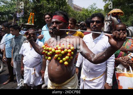 Un devoto indù con il suo corpo trafitto da aghi attaccati ai limoni partecipa ad una processione religiosa per celebrare il festival 'Muthu Mariamman' a Nuova Delhi, India, il 26 giugno 2022. Il festival, celebrato in India e nel subcontinente dell'Asia meridionale, dove si trovano importanti comunità tamil, presenta una delle più estreme manifestazioni di devozione religiosa al mondo. (Foto di Mayank Makhija/NurPhoto) Foto Stock