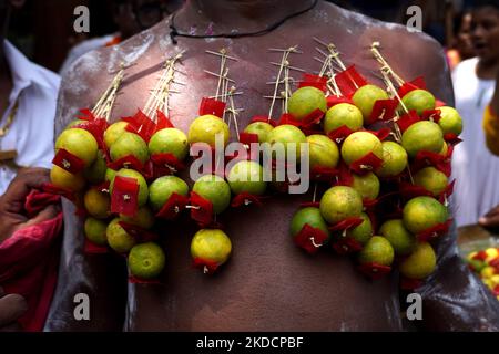 Un devoto indù con il suo corpo trafitto da aghi attaccati ai limoni partecipa ad una processione religiosa per celebrare il festival 'Muthu Mariamman' a Nuova Delhi, India, il 26 giugno 2022. Il festival, celebrato in India e nel subcontinente dell'Asia meridionale, dove si trovano importanti comunità tamil, presenta una delle più estreme manifestazioni di devozione religiosa al mondo. (Foto di Mayank Makhija/NurPhoto) Foto Stock