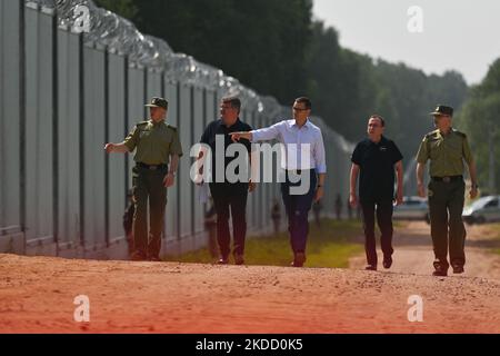 Il primo ministro Mateusz Morawiecki (al centro) è apparso al confine polacco-bielorusso al muro di confine, che il governo polacco ha definito una "barriera fisica". Ha partecipato alla consegna di questa struttura in acciaio e cemento alla Guardia di frontiera, da parte del contraente del progetto, società Budimex, Unibep e Budrex. Il muro di confine al confine polacco-bielorusso è stato costruito con l'uso di 50.000 tonnellate di acciaio. E 'alto 5,5 metri, sormontato da un filo rasoio e si estende per 186,25 km. Il Giovedi, 30 giugno 2022, a Nowodziel, nei pressi di Kuznica, Podlaskie Voivodato, Polonia. (Foto di Artu Foto Stock