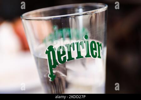 Il logo Perrier è visto su un bicchiere d'acqua in un ristorante a Madrid, Spagna, il 28 giugno 2022. (Foto di Jakub Porzycki/NurPhoto) Foto Stock