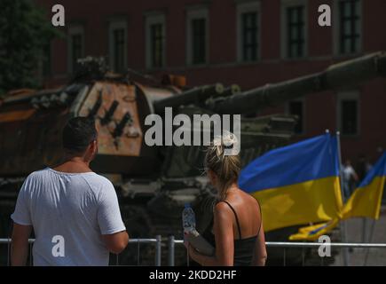 I turisti guardano l'howitzer Msta-S, semovente russo e parzialmente distrutto, catturato dall'esercito ucraino in mostra alla mostra "per la nostra libertà e la vostra" di fronte al Castello reale nella Città Vecchia di Varsavia. Venerdì 01 luglio 2022 a Varsavia, Polonia. (Foto di Artur Widak/NurPhoto) Foto Stock