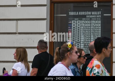 La gente passa davanti a un cartello con diversi tassi di cambio visti nella finestra di un ufficio di cambio nella città vecchia di Cracovia. Mercoledì 06 luglio 2022 a Cracovia, Polonia. (Foto di Artur Widak/NurPhoto) Foto Stock