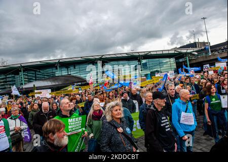 Gli attivisti del clima sono visti ascoltare i discorsi fuori dall'aeroporto durante la manifestazione. Centinaia di attivisti del clima si sono riuniti al di fuori di Schiphol per chiedere un piano climatico per l'aeroporto. Gli attivisti marciarono attraverso la sala principale all'interno dell'aeroporto, e camminarono fino al cantiere dove si costruì un nuovo terminal di Schiphol. Dopo di che, sono tornati e hanno ocuppato la sala principale per alcune ore, mentre altri attivisti all'esterno hanno bloccato diversi jet privati, perché secondo Greenpeace, i voli con questi aerei sono i più inquinanti. L'azione di massa distratta è stata la messa in campo Foto Stock