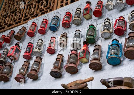 Lampade di kerosene vintage appesi su tutta la parete per la vendita in un negozio di Thrift Foto Stock