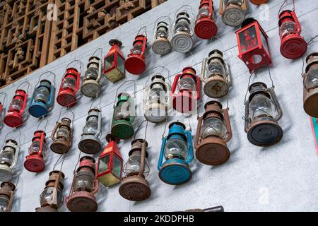 Lampade di kerosene vintage appesi su tutta la parete per la vendita in un negozio di Thrift Foto Stock