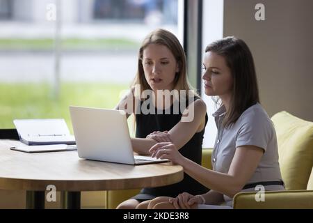 Due donne che lavorano insieme utilizzando un computer portatile Foto Stock