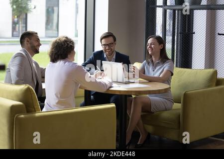 Gruppo di allegri impiegati che scherza impegnati in riunione Foto Stock