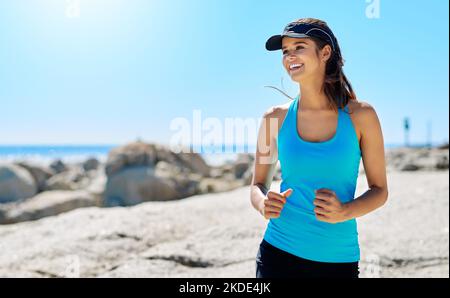 Correre mi fa sentire sano. Una giovane donna fuori correre. Foto Stock