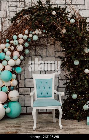 Sedia blu negli interni di Natale. Arco di Natale con palloncini Foto Stock