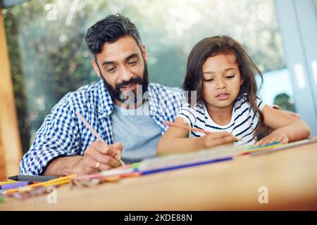 Divertirsi nel proprio spazio creativo, un padre e una figlia che si colorano insieme a casa. Foto Stock