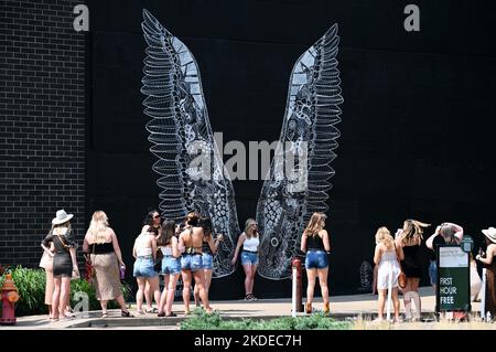 Giovane donna in posa di fronte al murale Angel Wings, Nashville, Tennessee, Stati Uniti d'America Foto Stock