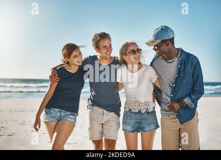 I loro ricordi preferiti sono stati fatti sulla spiaggia, un gruppo di giovani amici felici che si posavano sulla spiaggia insieme. Foto Stock