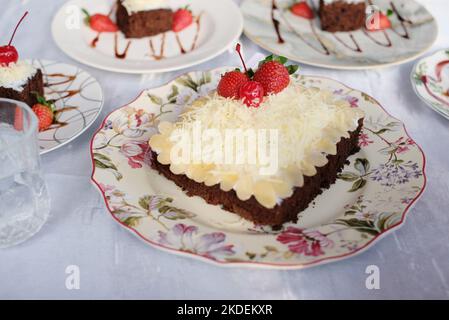 Torta quadrata con frutti di bosco. Torta quadrata su una foglia di banana Foto Stock