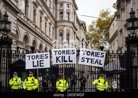 Cartelli al di fuori di Downing Street per protesta a Londra contro le misure di austerità del governo Tory che richiedono elezioni generali e salari più alti. Foto Stock