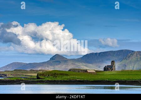 L'ex chiesa di San Edoardo sull'isola di Sanday, dall'isola di canna, Scozia, Regno Unito. Dietro si trovano le montagne dell'Isola di Rum. Foto Stock