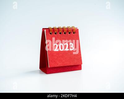 Buon natale e felice anno nuovo 2023 sfondo. numeri di anno lavorativo 2023 su moderna piccola scrivania calendario rosso coperchio isolato su sfondo bianco, m Foto Stock