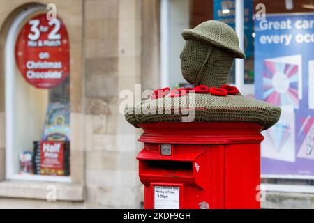 Chippenham, Wiltshire, Regno Unito, 6th Nov 2022. In vista del giorno della memoria, i bombardieri in filato hanno messo un omaggio lavorato a maglia ai militari e alle donne delle forze armate in cima a una casella postale Royal Mail nel centro di Chippenham. Credit: Lynchpics/Alamy Live News Foto Stock