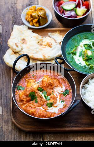 Pollo al burro, paneer saag, insalata di toatto e pane naan Foto Stock