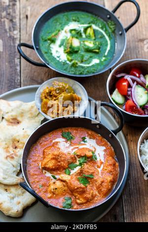 Pollo al burro, paneer saag, insalata di toatto e pane naan Foto Stock