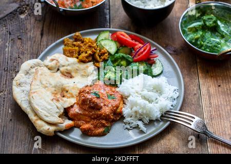 Pollo al burro, paneer saag, insalata di toatto e pane naan Foto Stock