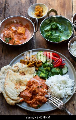 Pollo al burro, paneer saag, insalata di toatto e pane naan Foto Stock