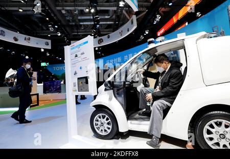 Shanghai. 6th Nov 2022. Un visitatore prova un veicolo elettrico del costruttore giapponese Toyota all'area di esposizione automobilistica della quinta China International Import Expo (CIIE) al National Exhibition and Convention Center (Shanghai) nella Shanghai della Cina orientale, 6 novembre 2022. La quinta edizione della China International Import Expo (CIIE) è prevista per il 5-10 novembre nel centro economico cinese di Shanghai. Molti veicoli verdi a basse emissioni di carbonio sono esposti durante la fiera. Credit: Fang Zhe/Xinhua/Alamy Live News Foto Stock