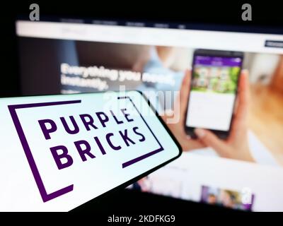 Smartphone con logo della società immobiliare Purplebricks Group plc sullo schermo di fronte al sito Web aziendale. Messa a fuoco a sinistra del display del telefono. Foto Stock