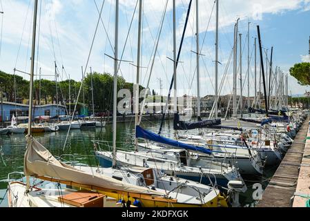 Barche a vela e motoscafi sono ormeggiati nel porto del Lago di Garda. Foto Stock