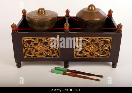 Kethuk Kempyang, uno strumento musicale indonesiano utilizzato nel gamelan giavanese. Gong in bronzo bilanciati su corda con una cornice decorativa in legno. Foto Stock