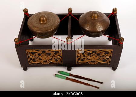 Kethuk Kempyang, uno strumento musicale indonesiano utilizzato nel gamelan giavanese. Gong in bronzo bilanciati su corda con una cornice decorativa in legno. Foto Stock