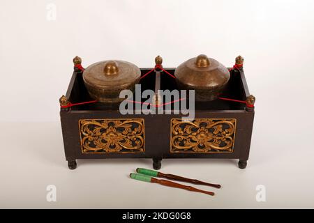 Kethuk Kempyang, uno strumento musicale indonesiano utilizzato nel gamelan giavanese. Gong in bronzo bilanciati su corda con una cornice decorativa in legno. Foto Stock