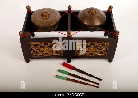 Kethuk Kempyang, uno strumento musicale indonesiano utilizzato nel gamelan giavanese. Gong in bronzo bilanciati su corda con una cornice decorativa in legno. Con Foto Stock