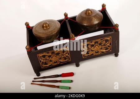 Kethuk Kempyang, uno strumento musicale indonesiano utilizzato nel gamelan giavanese. Gong in bronzo bilanciati su corda con una cornice decorativa in legno. Con Foto Stock