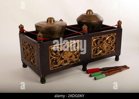 Kethuk Kempyang, uno strumento musicale indonesiano utilizzato nel gamelan giavanese. Gong in bronzo bilanciati su corda con una cornice decorativa in legno. Foto Stock