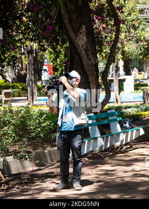 Cochabamba, Bolivia - Settembre 21 2022: Giovane indigeno con maschera nera spara video con fotocamera in un giorno di sole Foto Stock