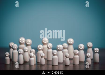 Bambola di legno per una vita felice, faccia sorridente, assistenza sanitaria, sana, consapevolezza, benessere, concetto di assicurazione familiare isolato su azzurro con spazio copia Foto Stock