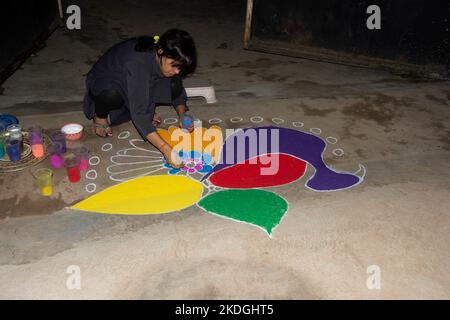 Popoli tribali che disegnano rangoli alla vigilia di Diwali Foto Stock