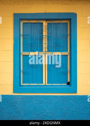 Finestra blu su sfondo giallo, caratteristica della città di Jerico, Antioquia, Colombia Foto Stock